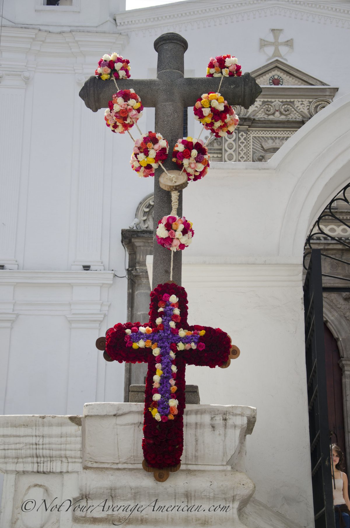 The rose draped cross in the afternoon light in front of the Convento del Carmen Alto | ©Angela Drake