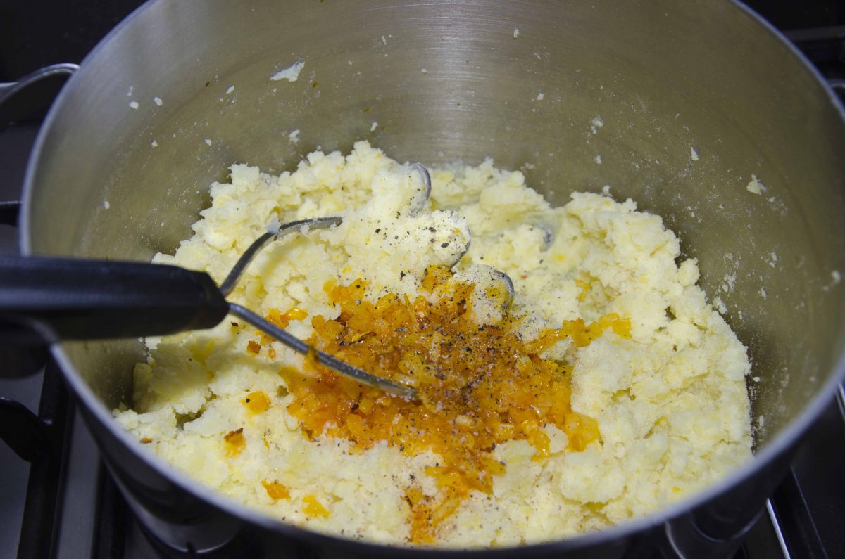 Mash the cooked and drained potatoes. Add the sauteed onions. Mash the cooked and drained potatoes. Add the sauteed onions.