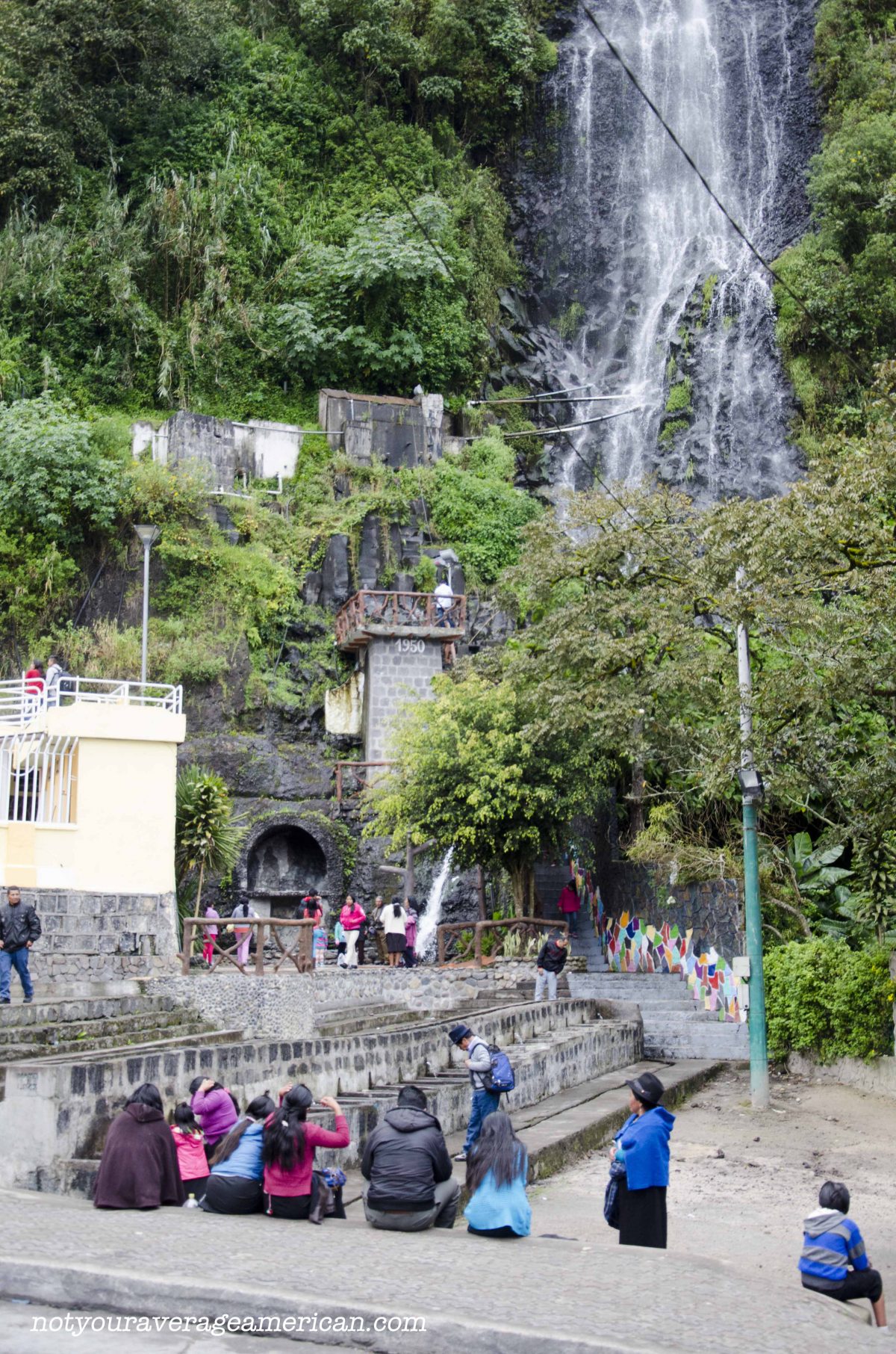 Visitors sitting at the base of La Cabellera de la Virgin (the Virgin's Tresses) in Baños, Ecuador.