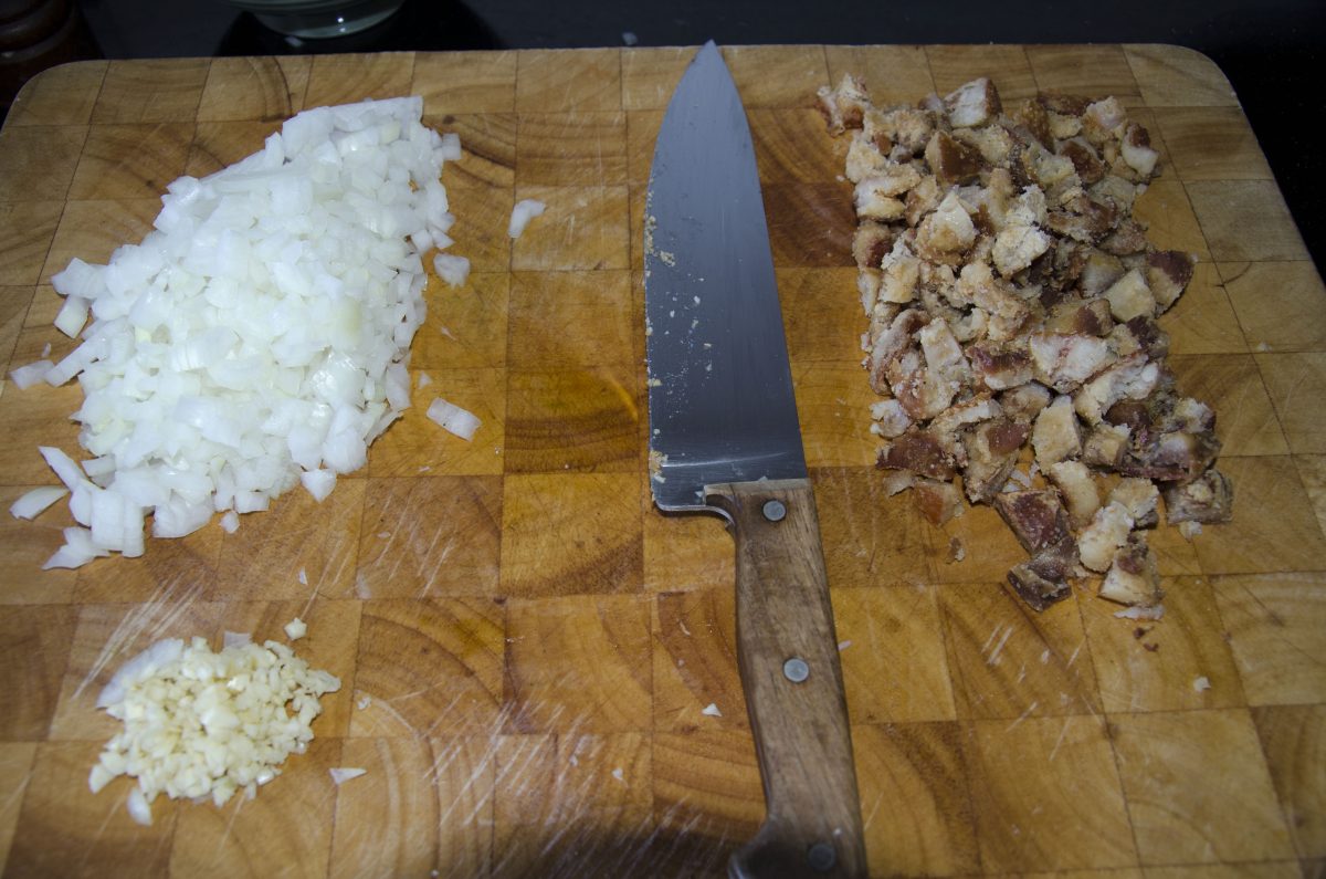 Dice the onions, mince the garlic, and chop the chicharron or other meat into small, bite size pieces.