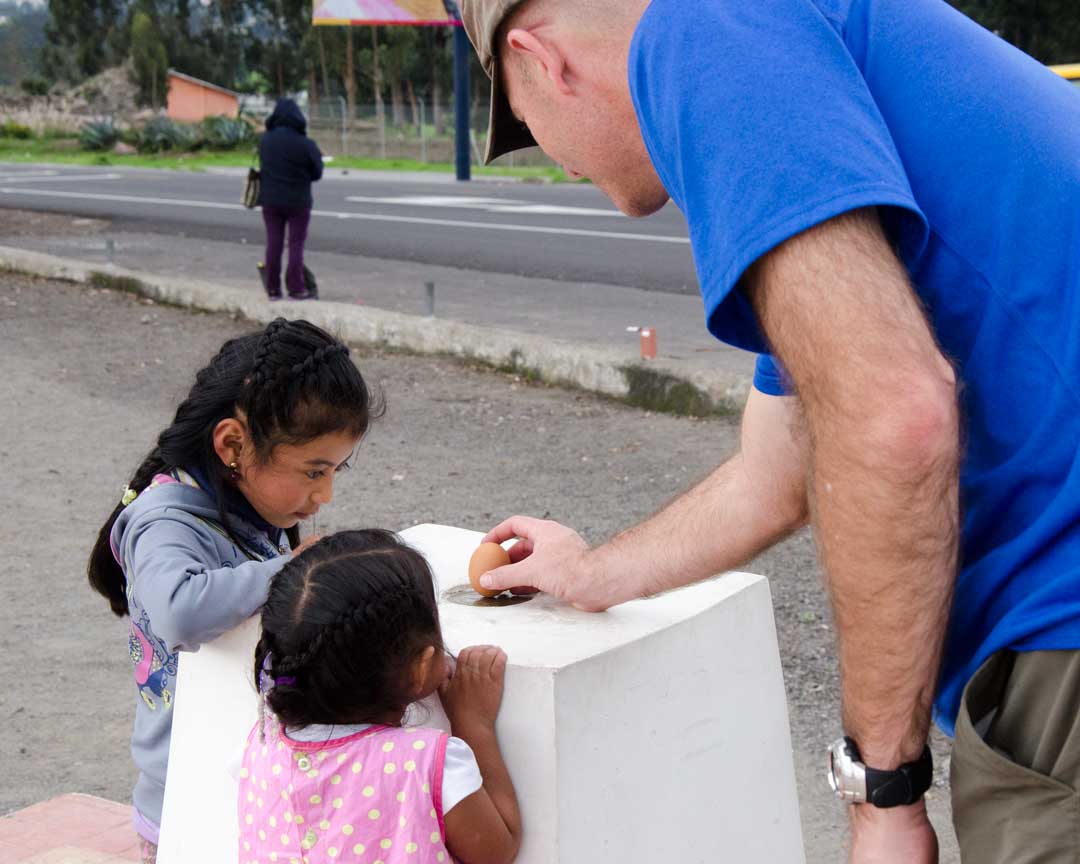 Balancing an Egg at the authentic Mitad del Mundo; Buena Esperanza, Cayambe, Ecuador | ©Angela Drake