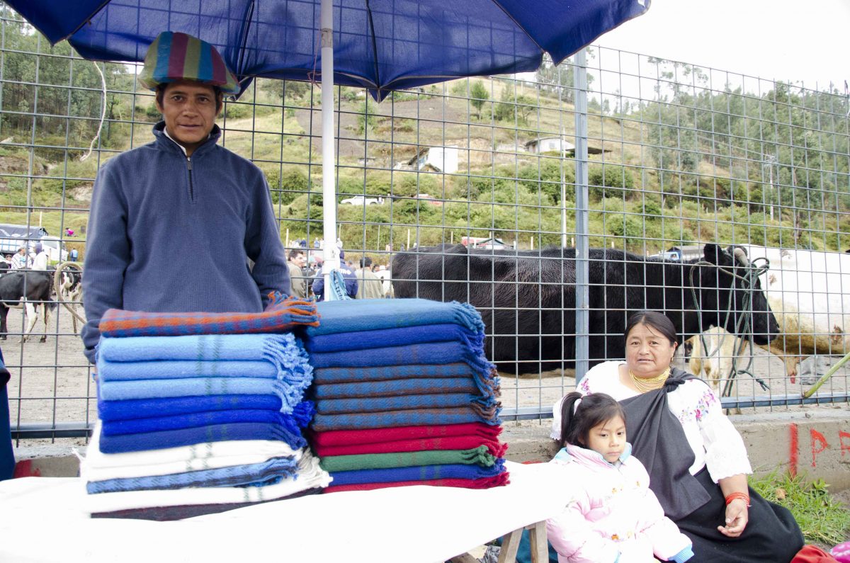 Blanket Vendor and family at the animal market, Otavalo, Ecuador | ©Angela Drake