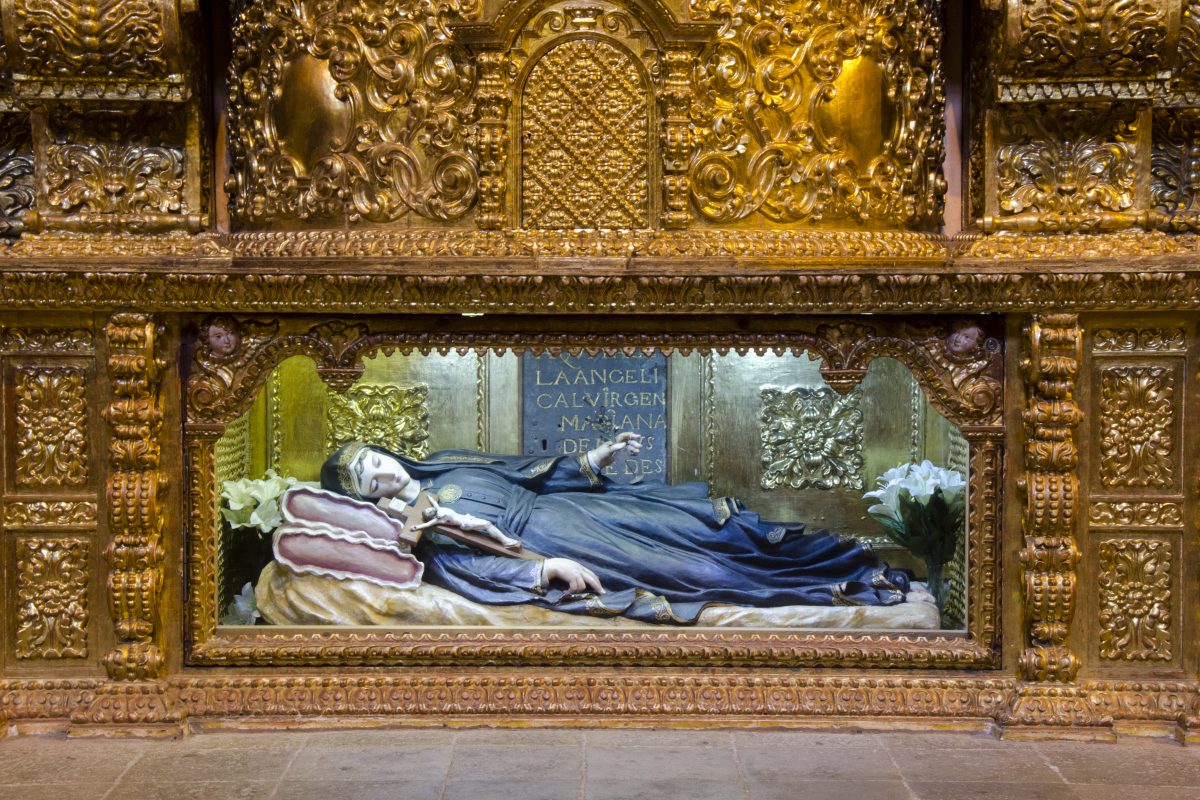 A statue of Mariana de Jesus laid in rest at the base of an altar