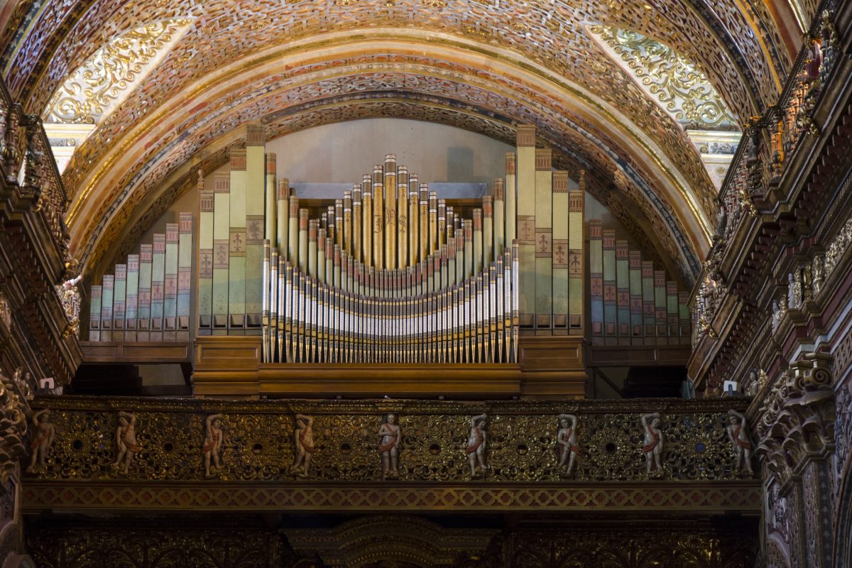 The organ at the Compania de Jesus is also a piece of artwork | ©Angela Drake An intricate organ in gold and silver sits below an archway in the choirstall below