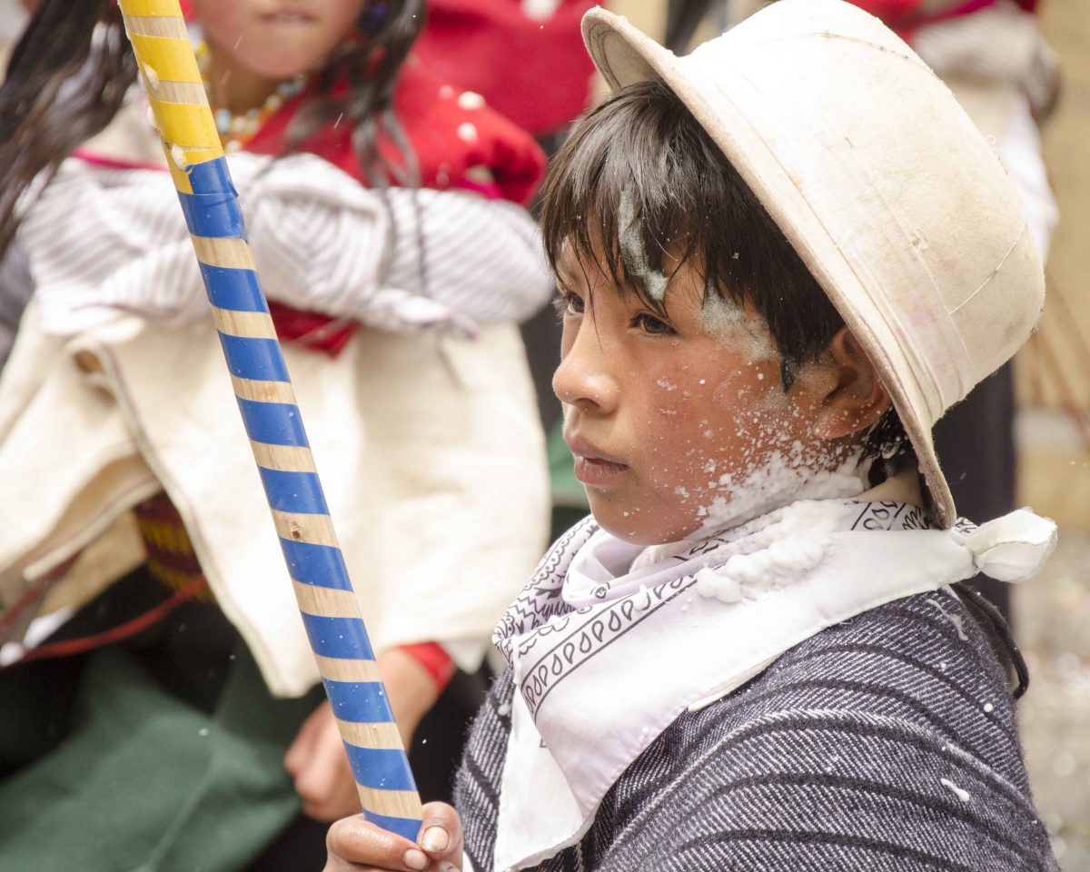 A young boy walks the parade route; Carnival in Guamote, Ecuador | ©Angela Drake Carnaval in Guamote