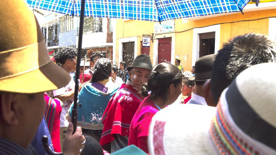 People standing in shade of an umbrella