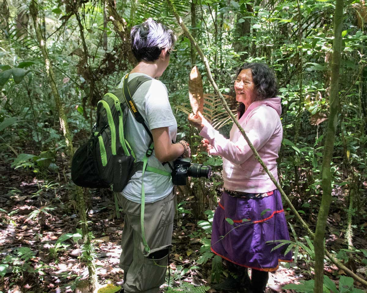 A local Siona guide explaining a medicinal plant to a visitor | Cuyabeno, Ecuador | ©Angela Drake