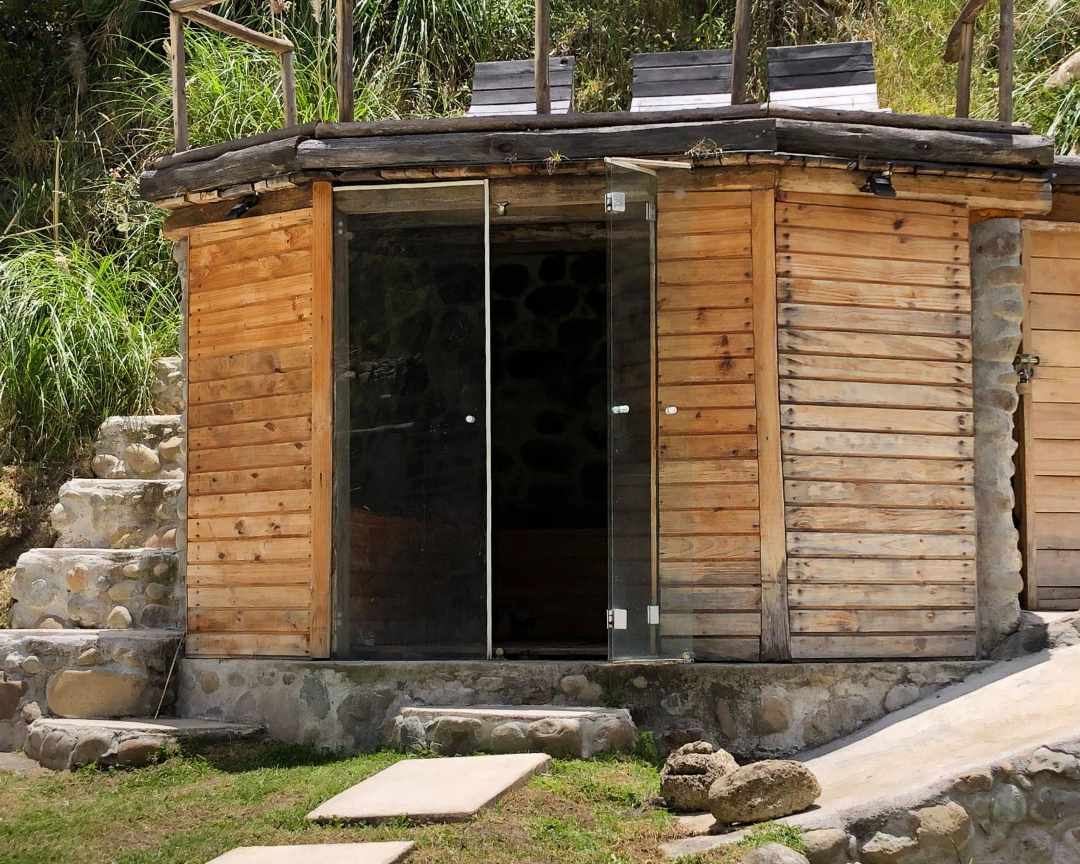 Rustic wood building with glass doors leading to a sauna