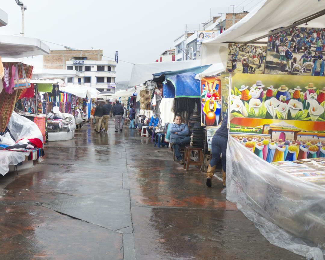 Puestos de mercado y una acera mojada en un día lluvioso