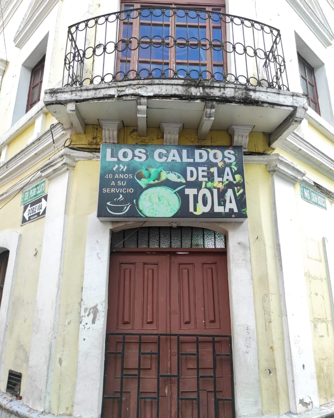 Las Caldos de La Tola, Quito, Ecuador | ©Jacqueline Granda Marcillo A sign above a wooden door says "Los Caldos de La Tola"
