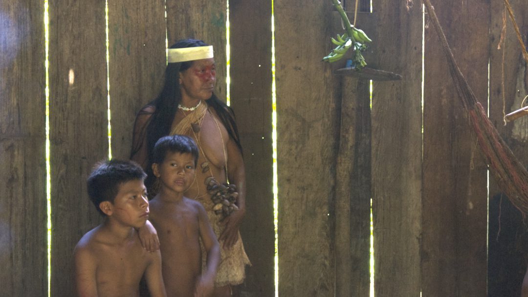 A Huaorani women in traditional class and two young Huaorani boys with bare chests