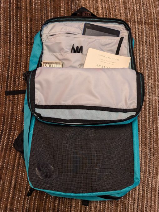 Folded front of Six Moon's ADC Backpack includes pockets to hold office gear like pens, business cards, Kindles and books.