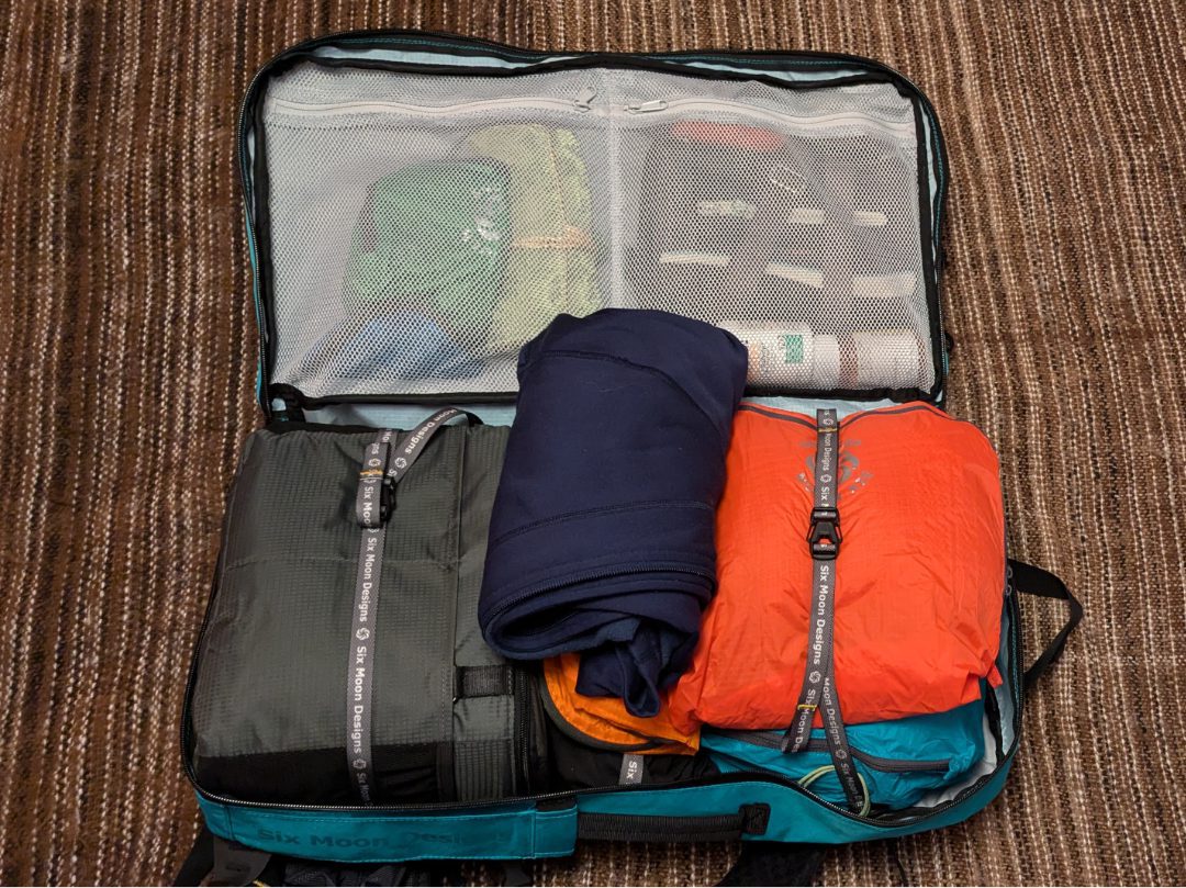 Fully packed ADC Travel Backpack using with a Tenba Soft Case, Travel Pods, and jacket showing.