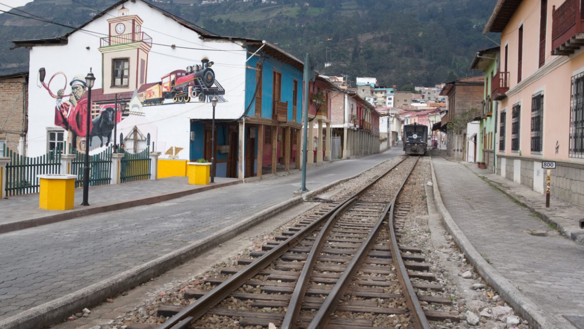 Train tracks run between colonial style buildings in the town of Alausí, Ecuador