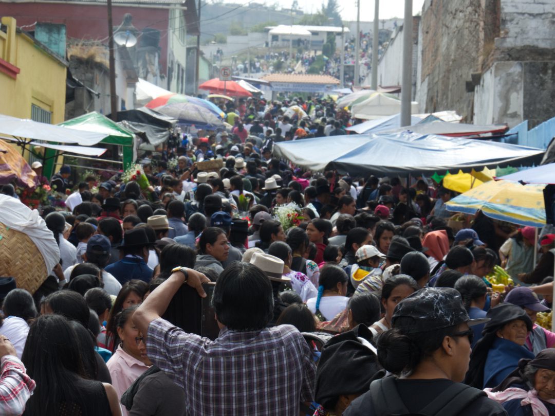 A narrow street leading to the cemetery entrance is full of people on the Ecuadorian Day of the Dead in Otavalo, Ecuador