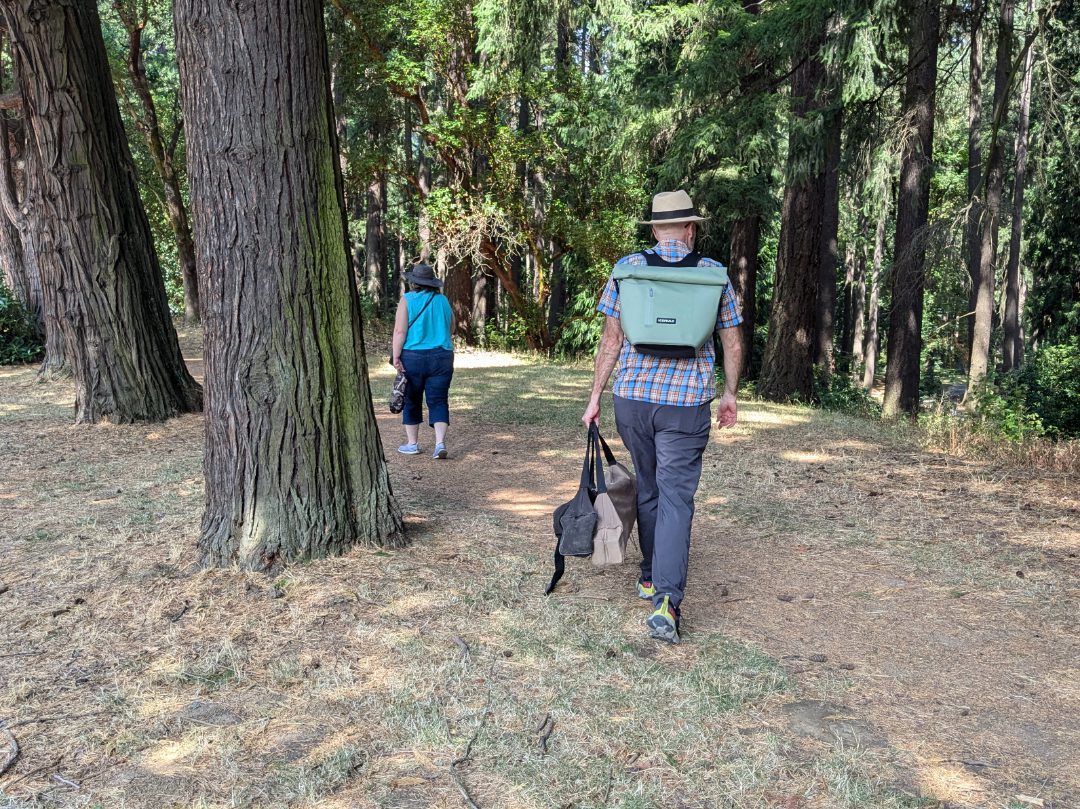 A man walkig in the woods while wearing the ICEMULE Jaunt 20L backpack cooler