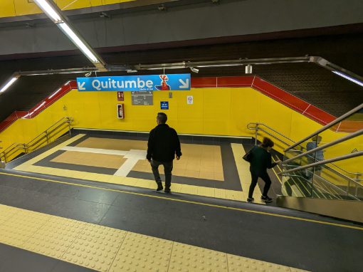 Two people on the stairs heading into the Quito Metro. Only one is keeping to the right.