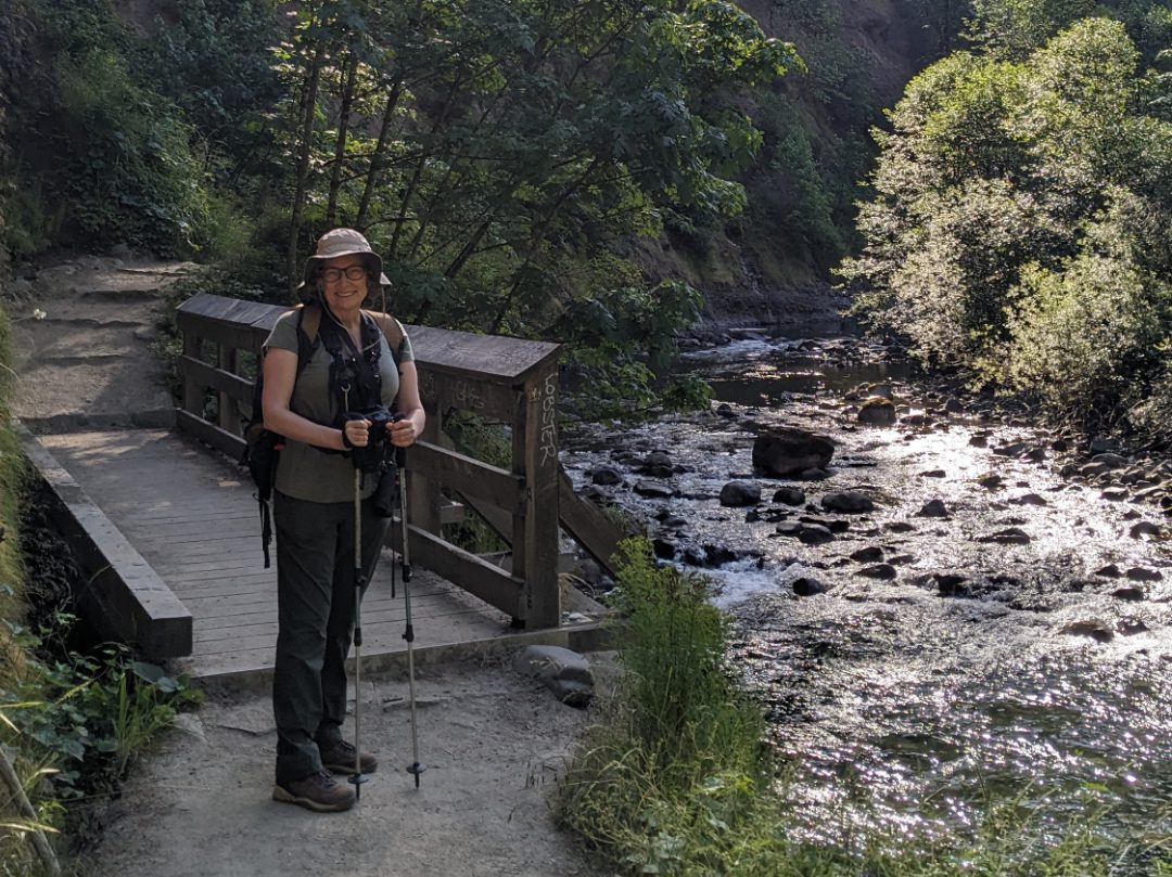 Angie on Eagle Creek Trail Angie with full hiking gear stadning in front of a bridge crossing a small creek enters Eagle Creek.