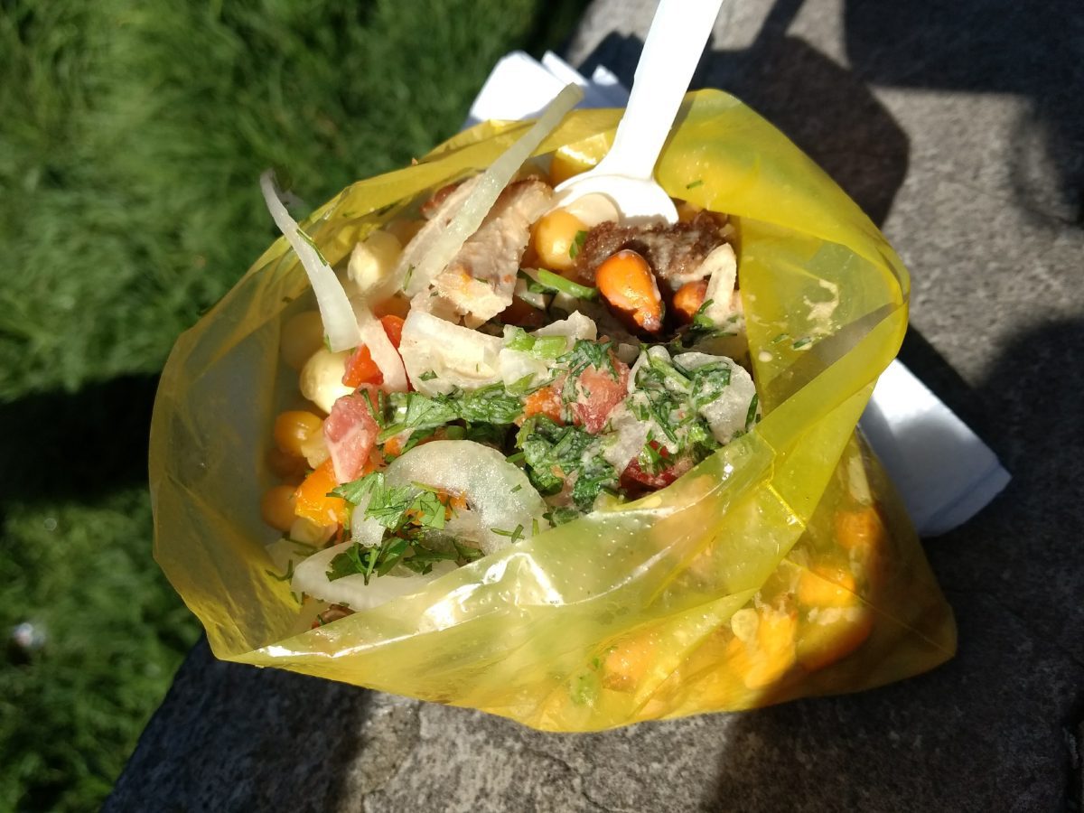 Bolsa amarilla brillante llena de cevichochos, un plato tradicional andino con chochos, cerdo, maíz, tostado, tomate, cebolla y ají.