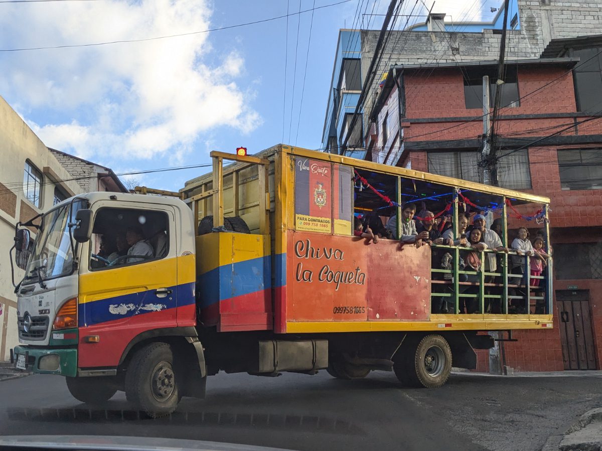 A traditional chiva decoraged in the colors of Quito and Ecuador is full of partying guests.