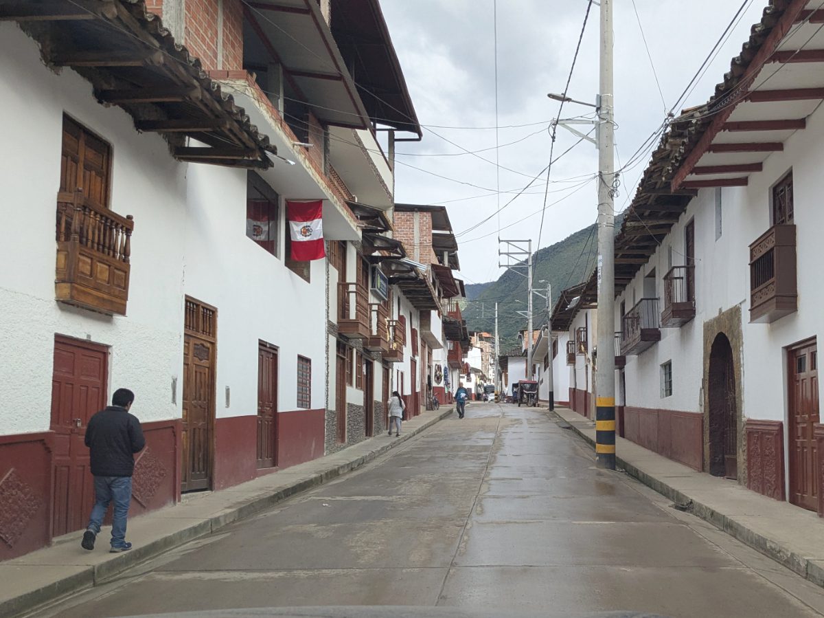 The buildings of downtown Leymebamba are painted wait and oxblood red with wooden doors and balconies.