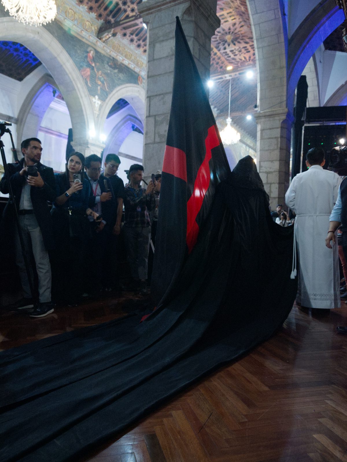 The flag bearer dragging a black cape through the cathedral at the Arrastre de Caudas in Quito