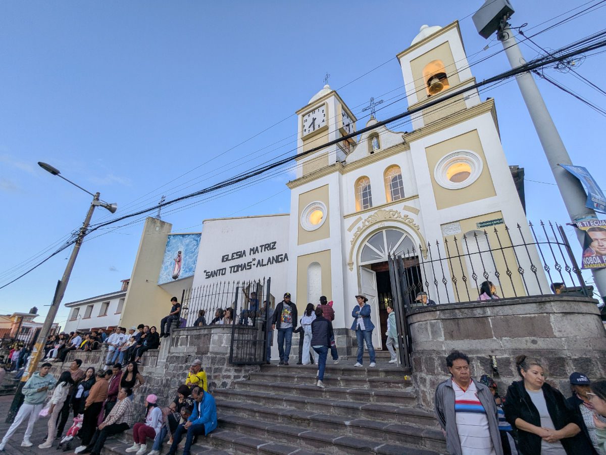 People waiting outside the colonial church in the plaza of Alangasí, Ecuador