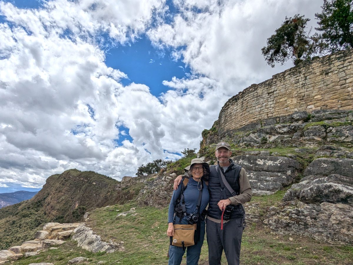 Scott and Angie pose below an ancient stone wall at Kuelap, Peru