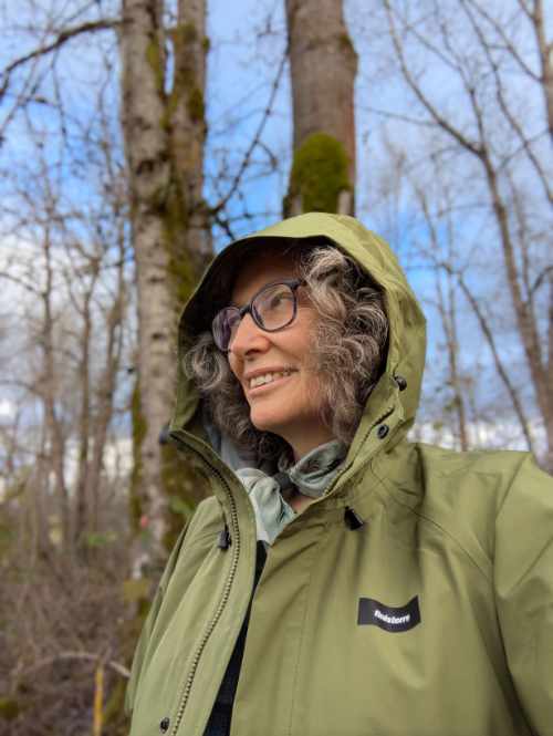 Angie wearing the moss green Skybird rainjacket by Finisterre